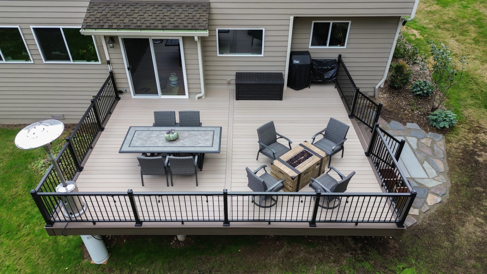 Aerial view of the pressure treated wood decking with black metal railing and outdoor living furniture and fireplace in miami valley oh