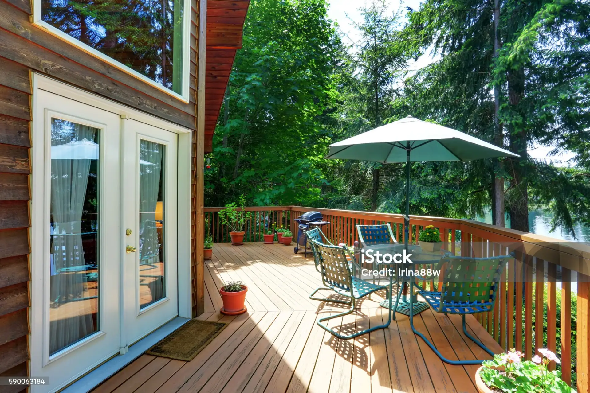 Balcony house exterior with patio area and opened green umbrella on the forest in miami valley oh