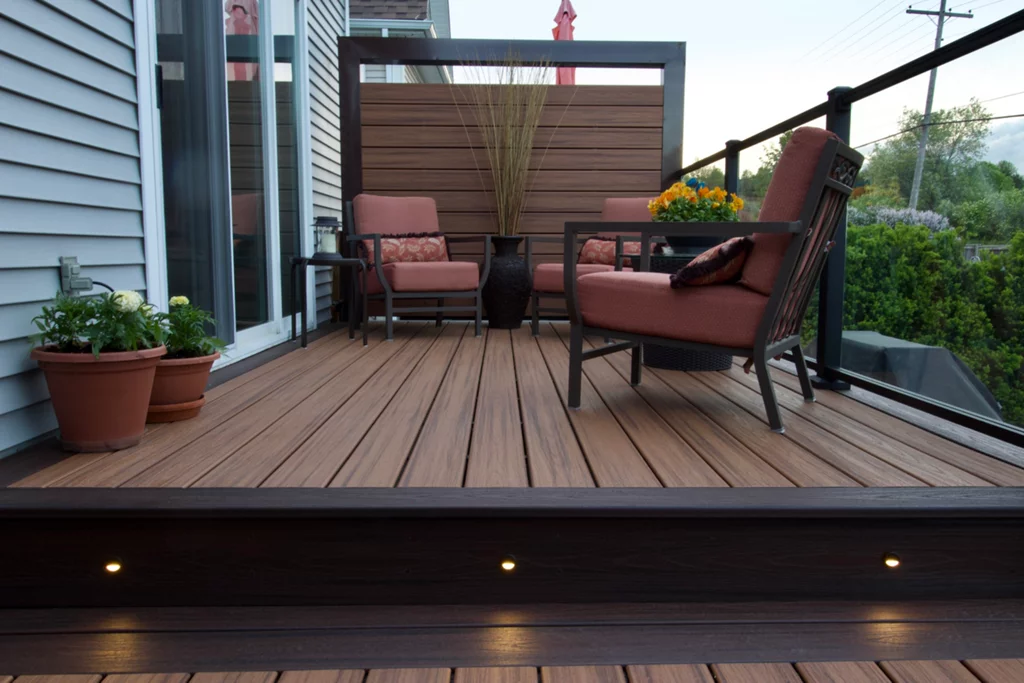 Glass railing privacy wall on the composite deck with lighting on deck stairs steps with outdoor living furniture in miami valley oh