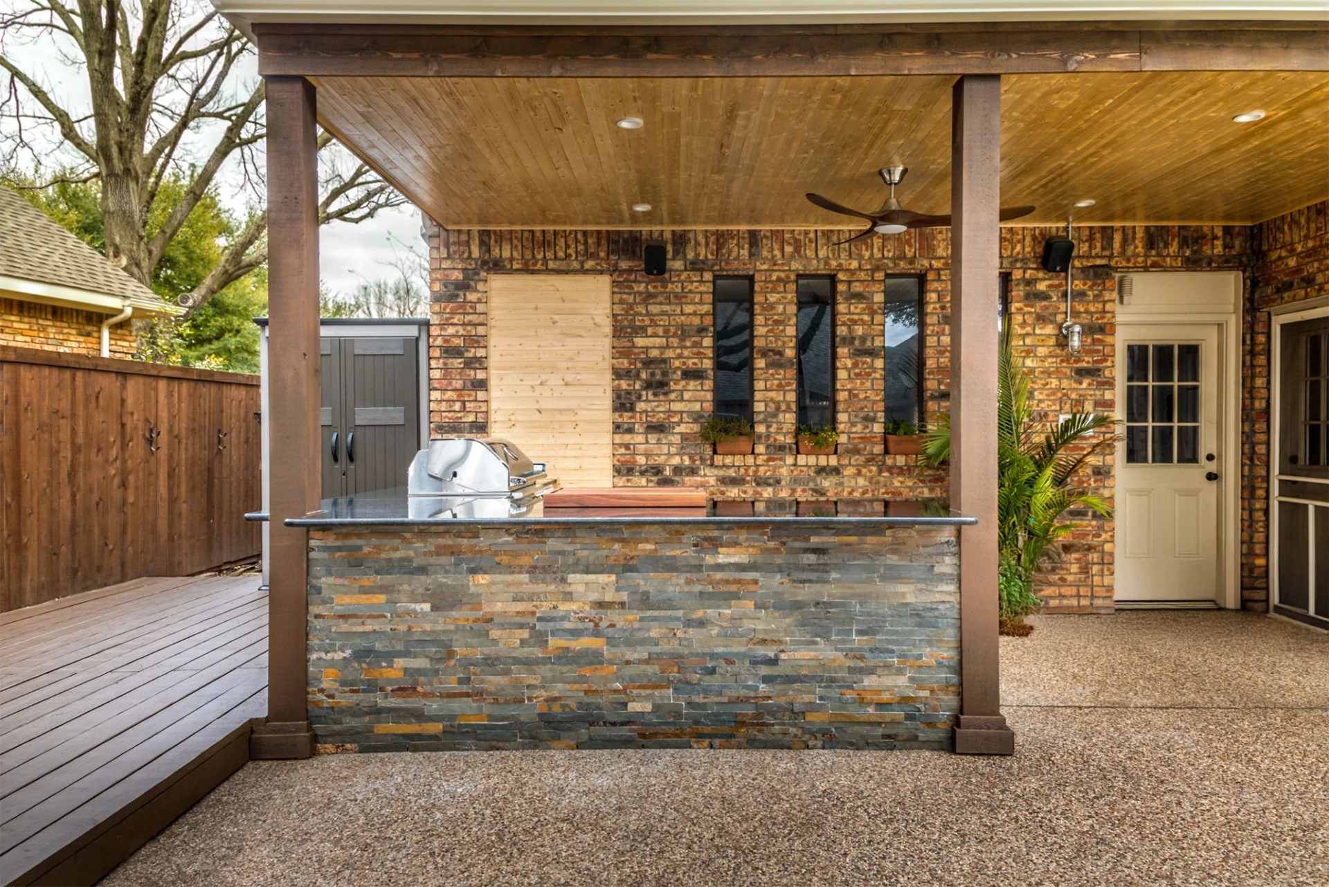 Modern outdoor living kitchen that has been freshly built with wooden fence in miami valley oh