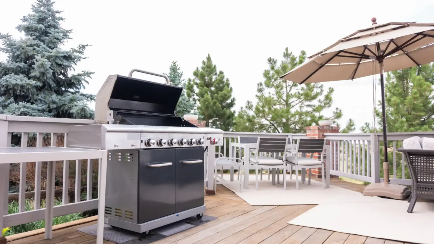 Outdoor kitchen patio with chairs and standing umbrella in miami valley oh