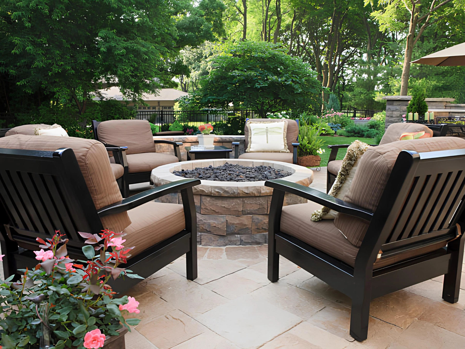Paver patio with outdoor firepit featuring plants and trees on the background in miami valley oh