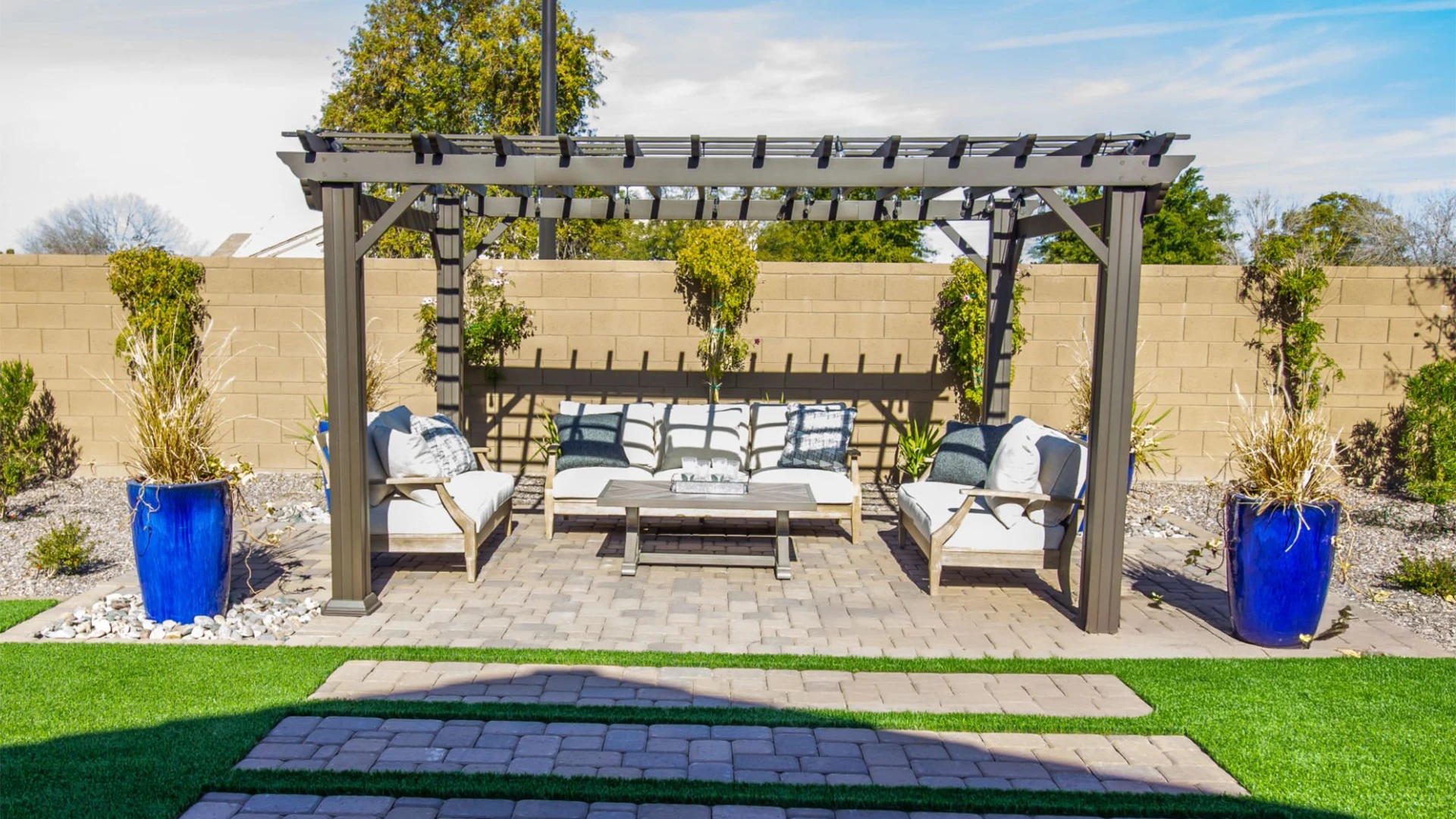 Pergola backyard arbor covering three couches with brick wall privacy fence in miami valley oh