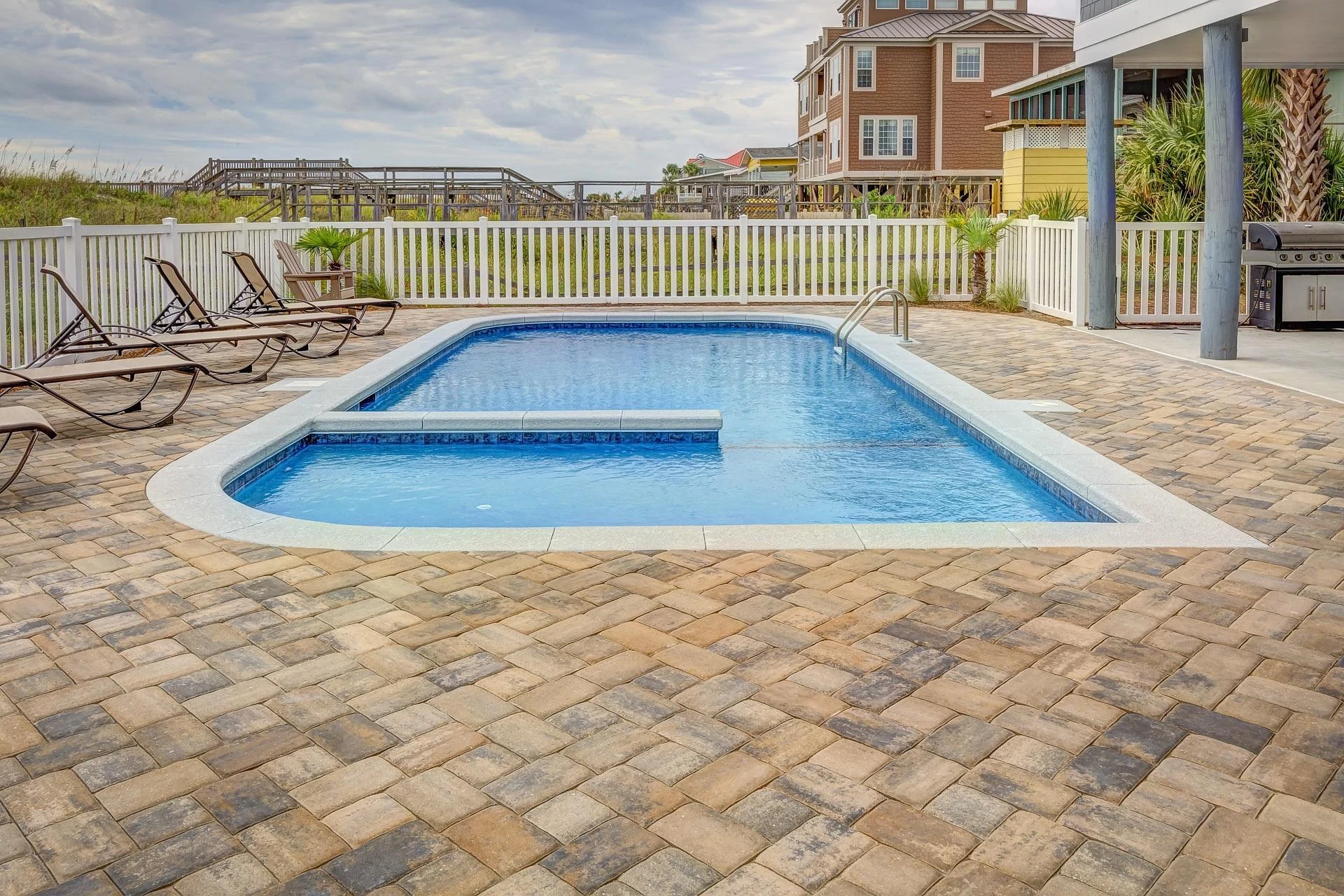 Pool white fence with outdoor kitchen and overlooking nature view in miami valley oh