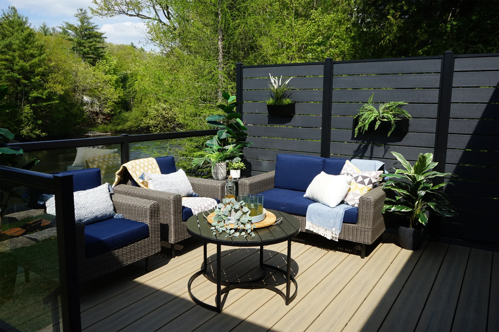 Privacy slats with plants on the commercial deck with glass railing and outdoor living furniture on the lake in miami valley oh