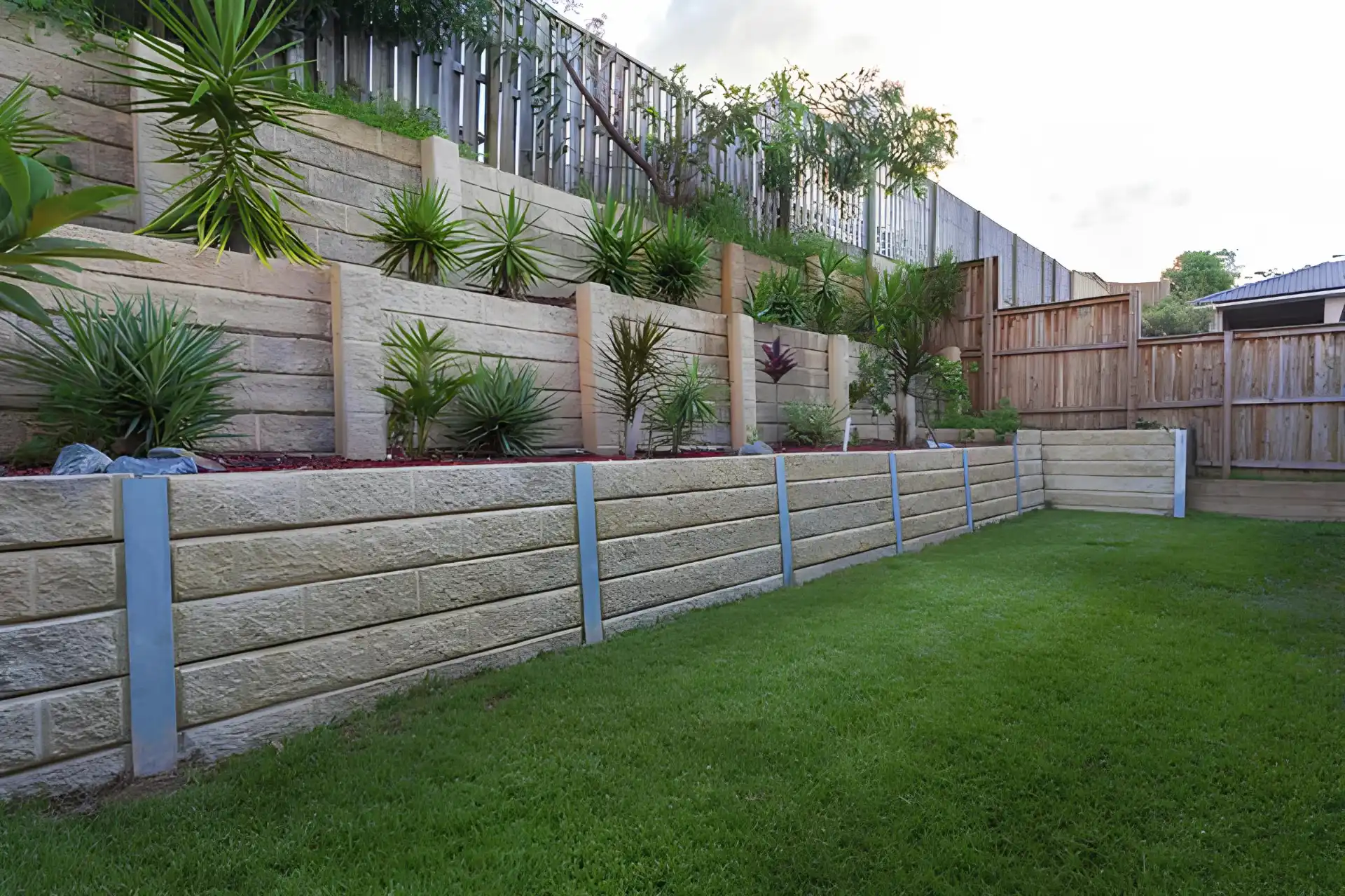 Retaining wall with plants design on it and wooden fence in miami valley oh