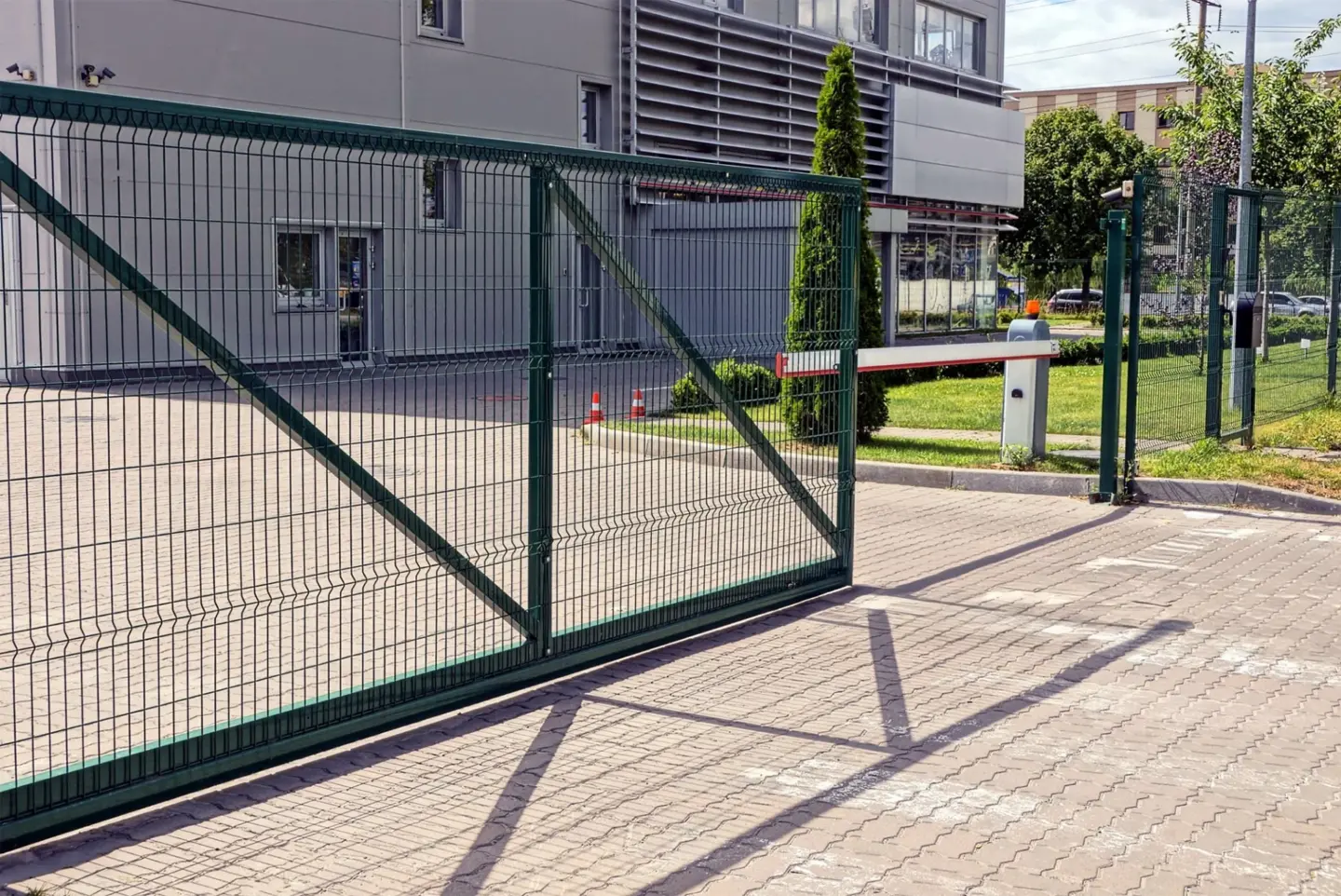 Security fence with green metal gate and barrier on the sidewalk in front of the industrial building in miami valley oh